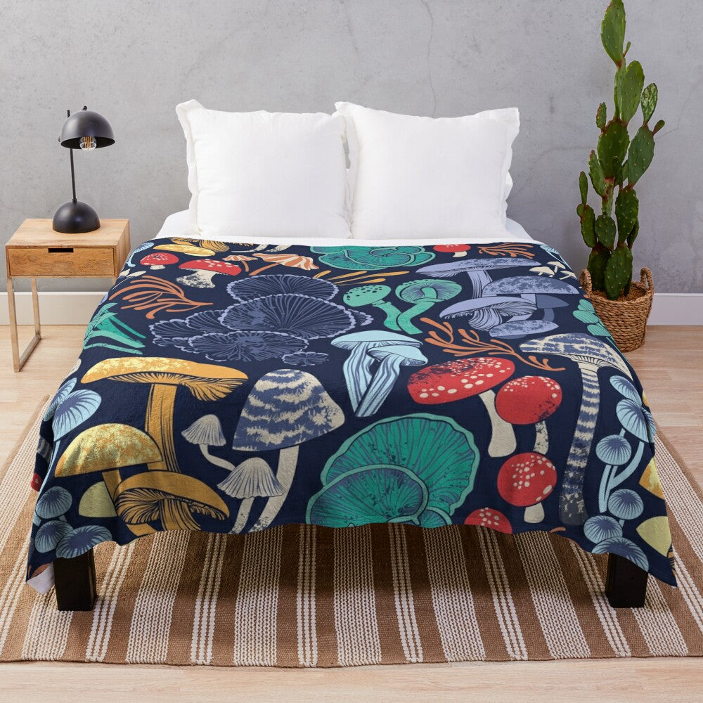 Plush blanket with multicoloured wild mushroom illustrations on a midnight blue background