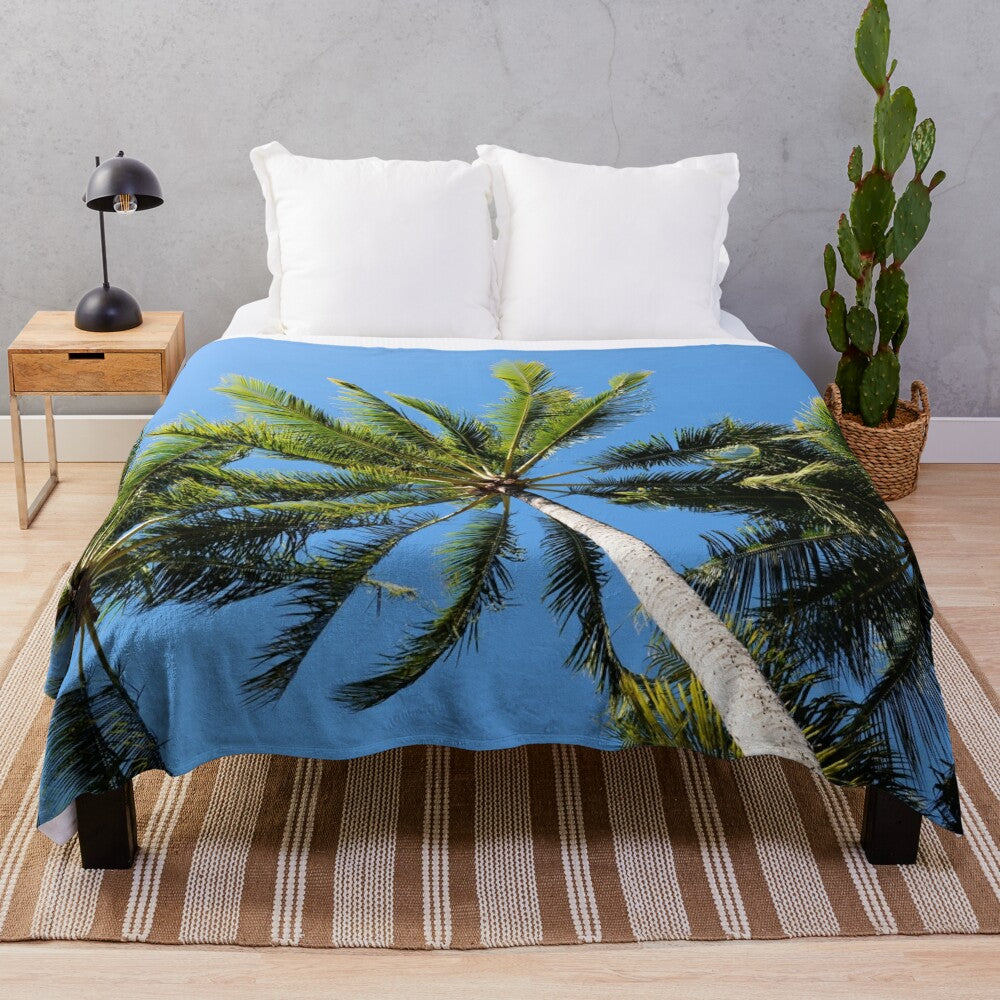 Plush blanket with three palm trees against a blue sky