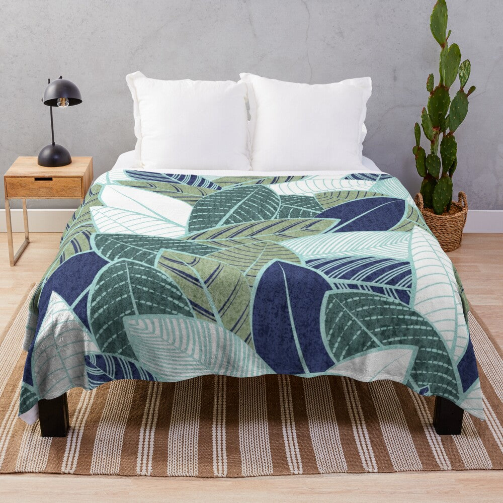 Plush blanket featuring a leaf wall design in navy blue, pine, and sage green