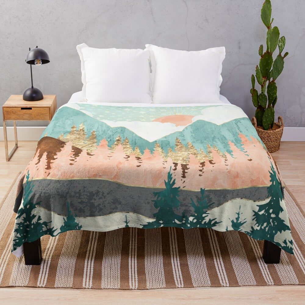 Plush throw blanket featuring a winter forest landscape with mountains, stars, and a celestial design