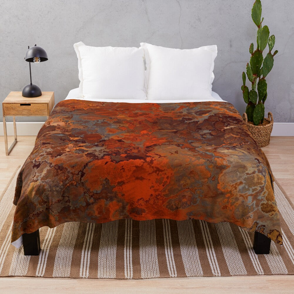 A soft, plush blanket with a metallic gold and rust abstract design