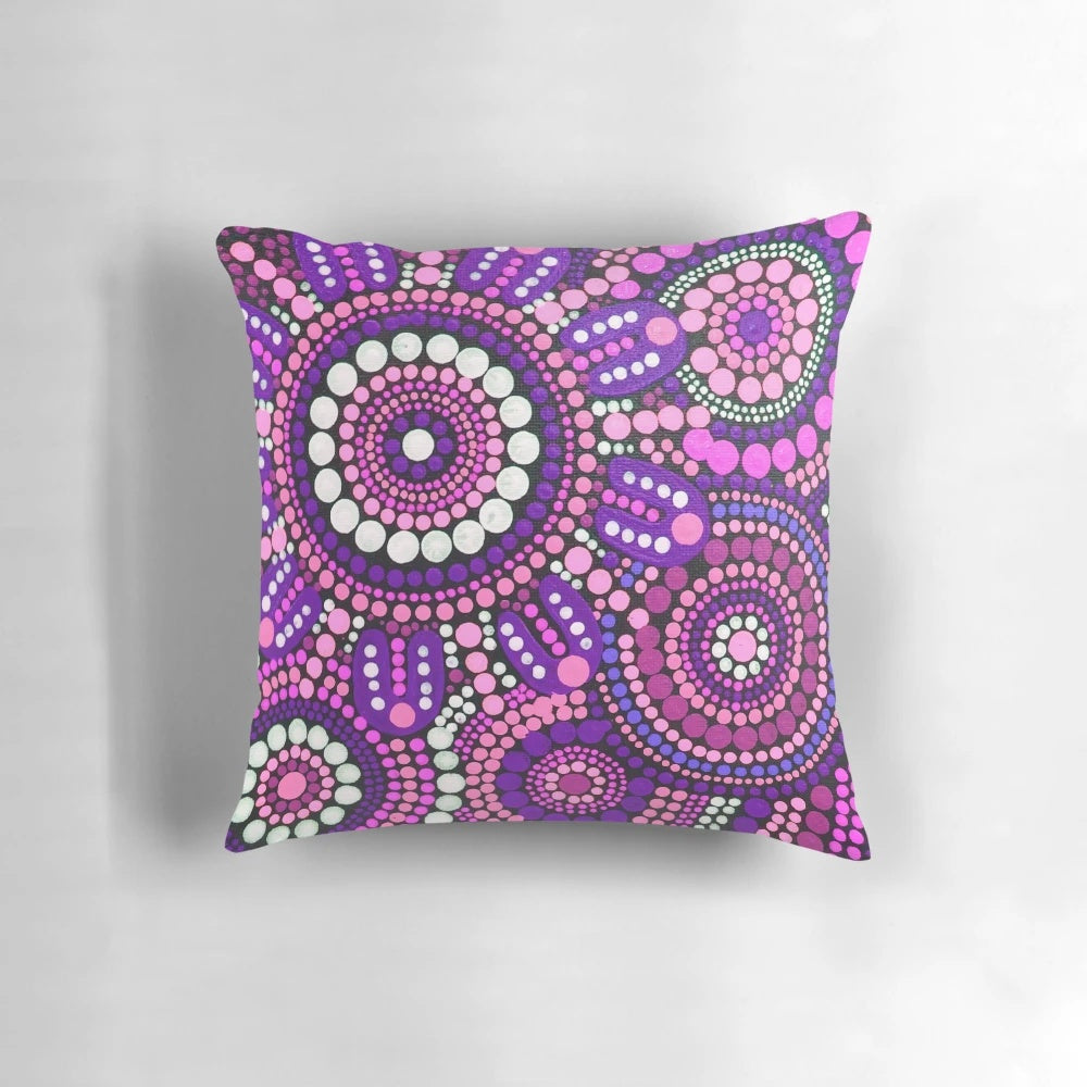 Colorful aboriginal art pattern in shades of pink adorns a plush throw pillow, perfect for creating a welcoming atmosphere in your home.