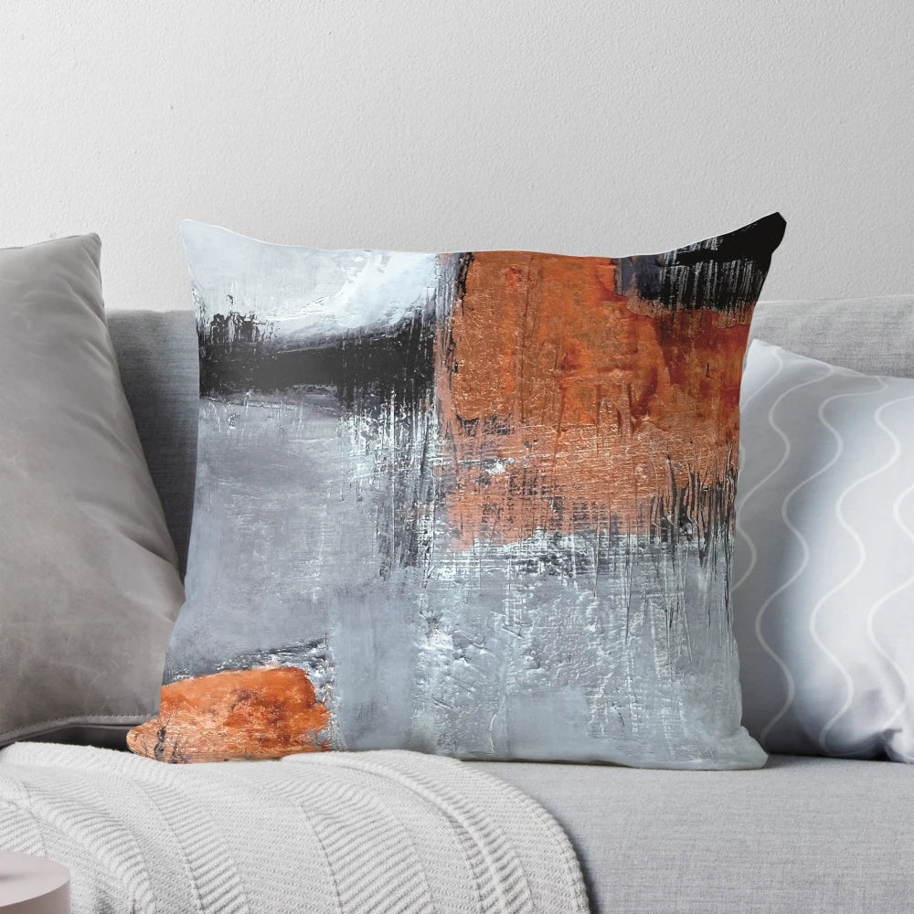 A modern abstract throw pillow in black and orange with a textured, geometric design