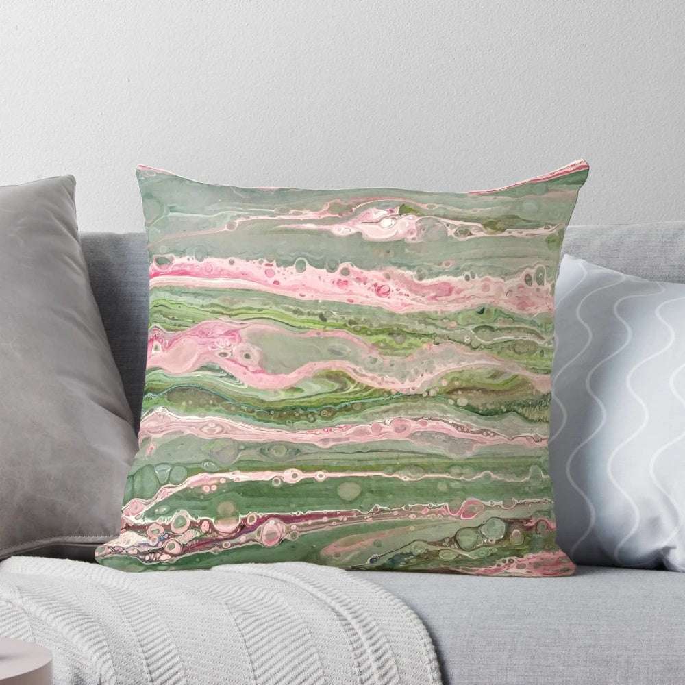 Colorful abstract art acrylic pour design on a decorative throw pillow in pink and green stripes.