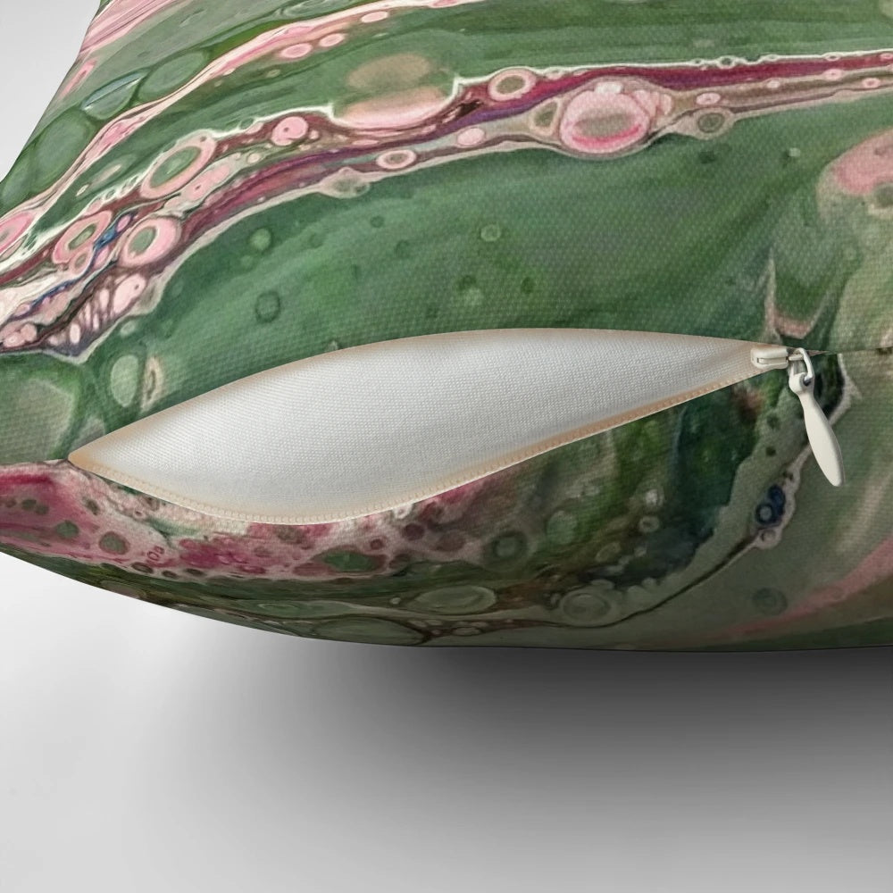 Colorful abstract art acrylic pour design on a decorative throw pillow in pink and green stripes.