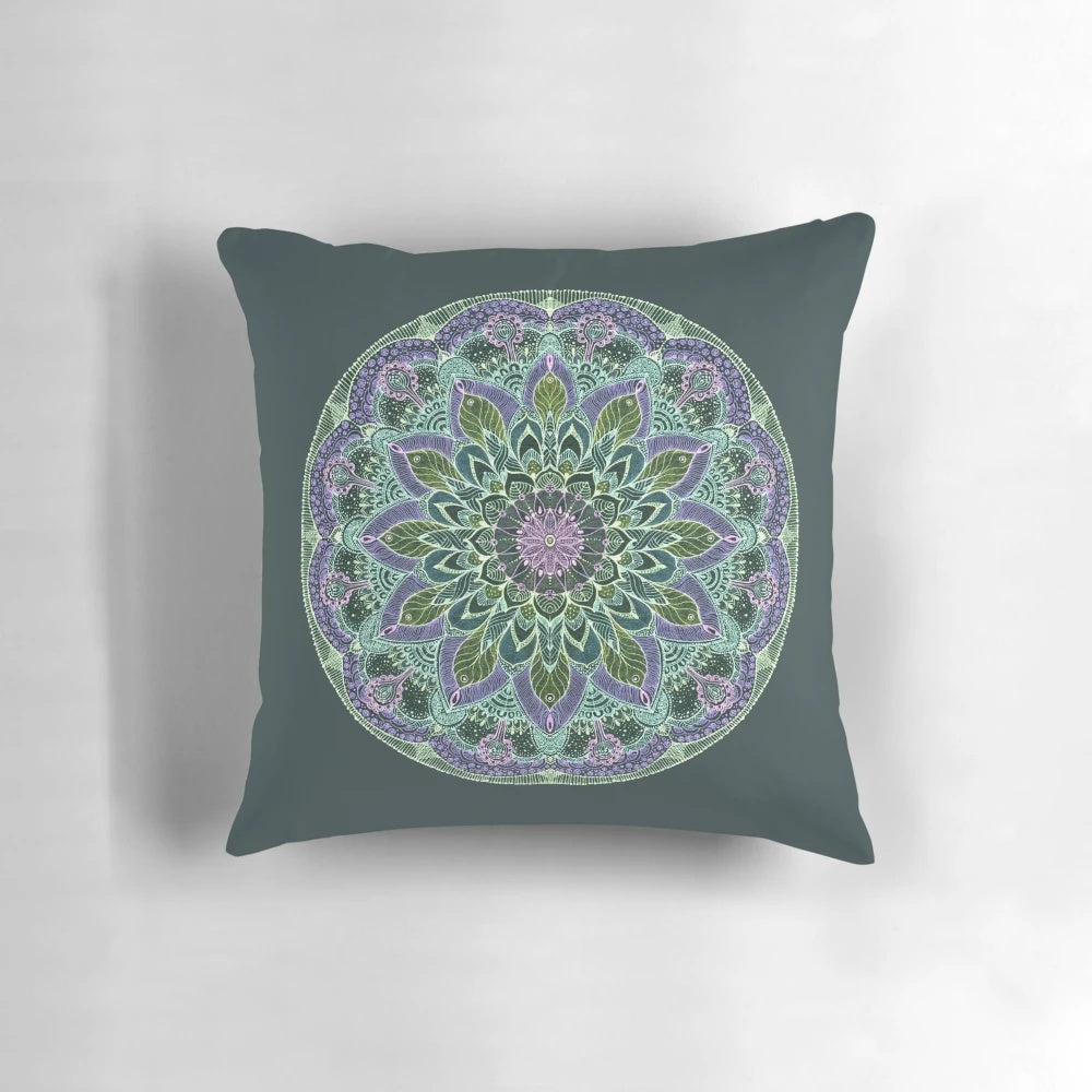 Closeup of a hand-drawn abstract mandala design on a dark-colored throw pillow