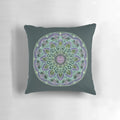Closeup of a hand-drawn abstract mandala design on a dark-colored throw pillow