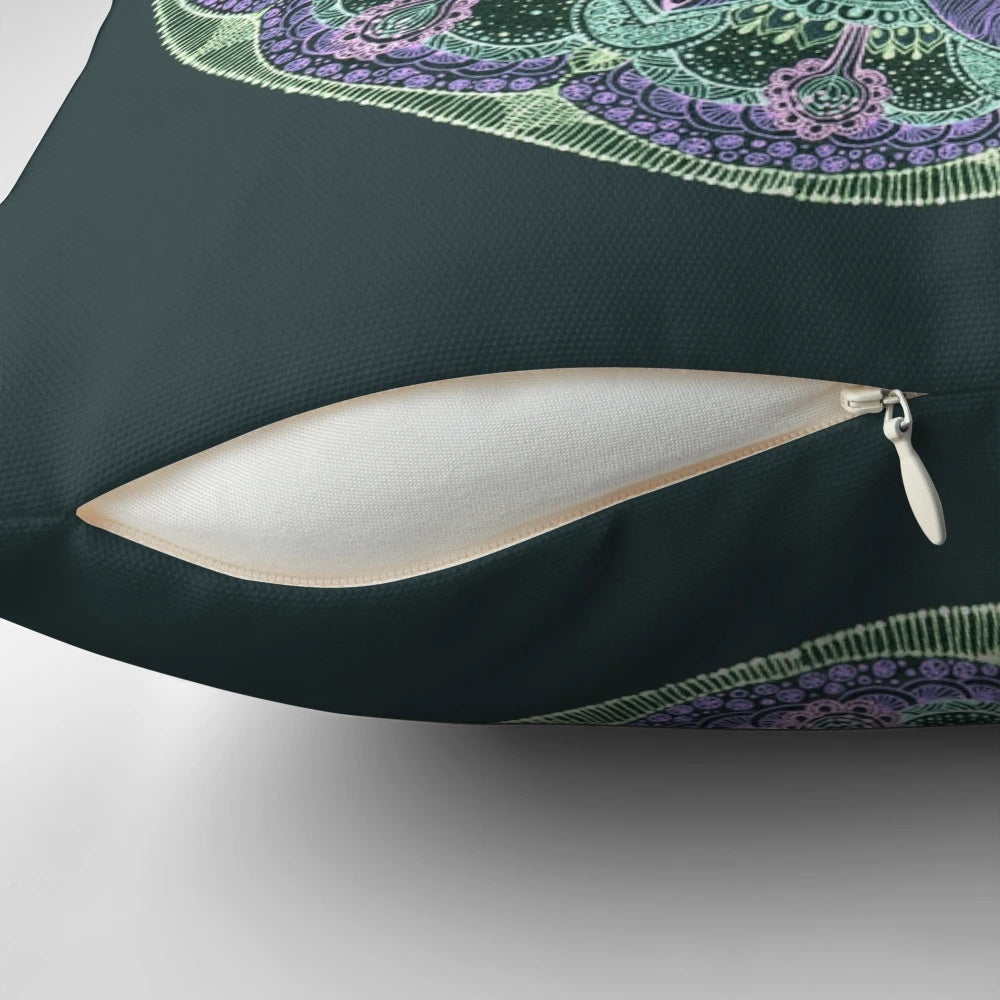 Closeup of a hand-drawn abstract mandala design on a dark-colored throw pillow