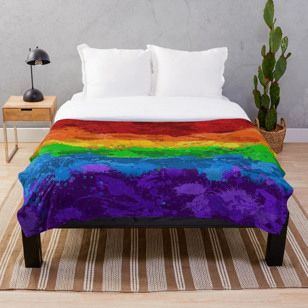 Colorful abstract paint splatter pattern on a plush blanket