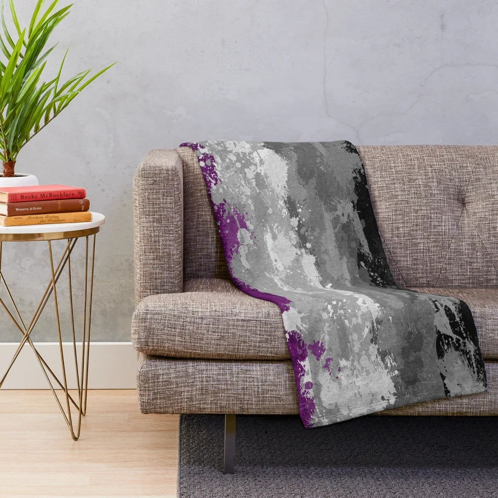 Plush blanket featuring an abstract paint splatter design in the colors of the asexual pride flag