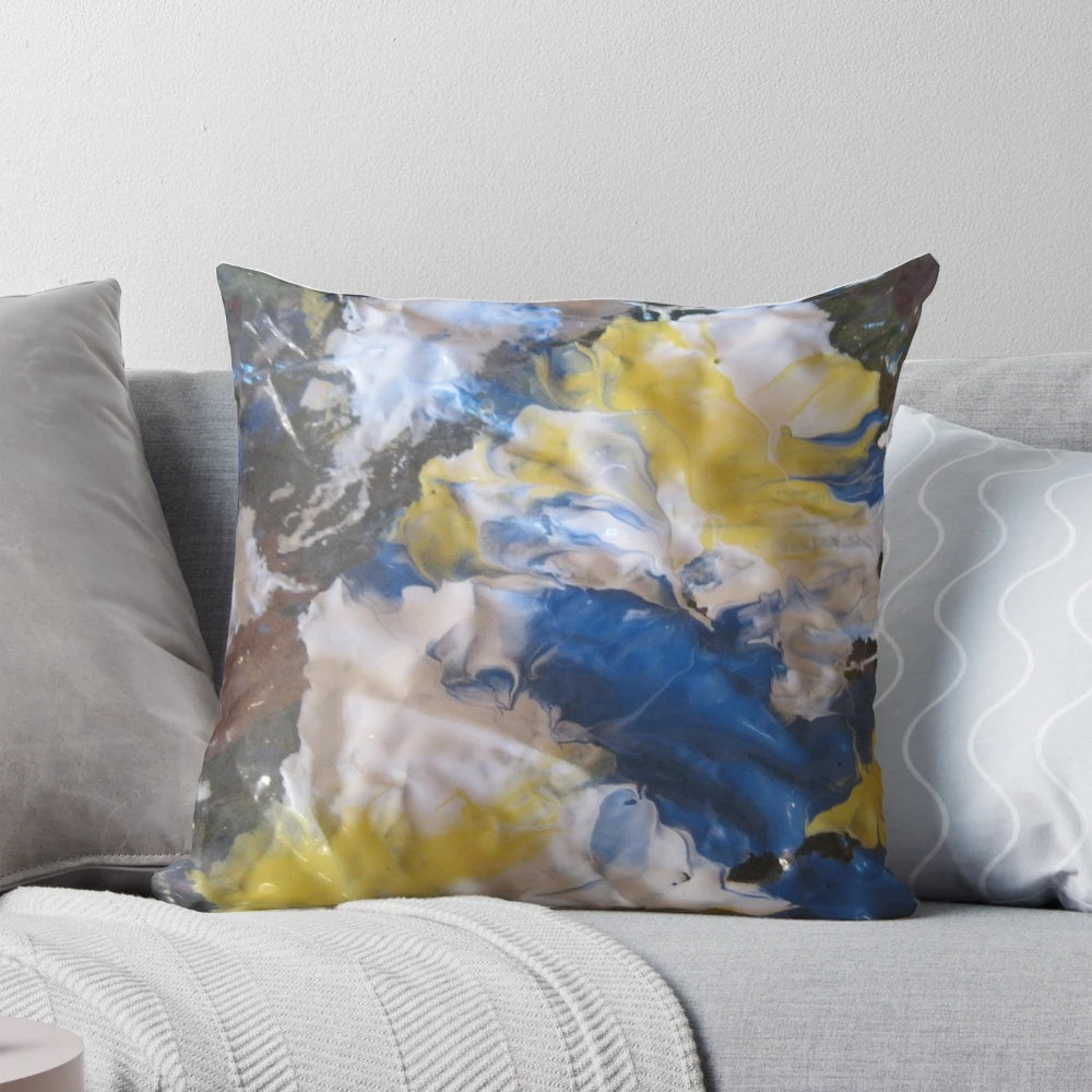 Vibrant abstract patterned pillow in shades of blue, yellow, and white