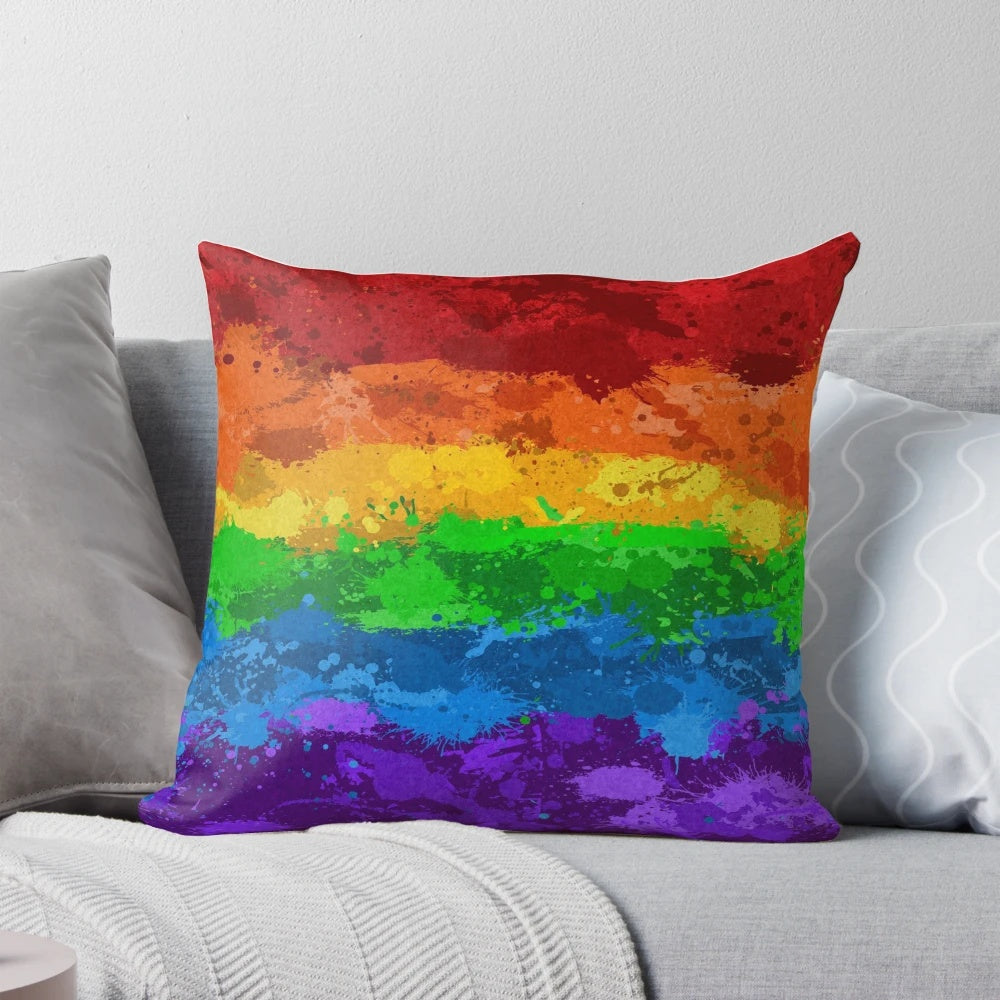 Colorful abstract paint splatter pattern in LGBTQ pride colors on a pillow.