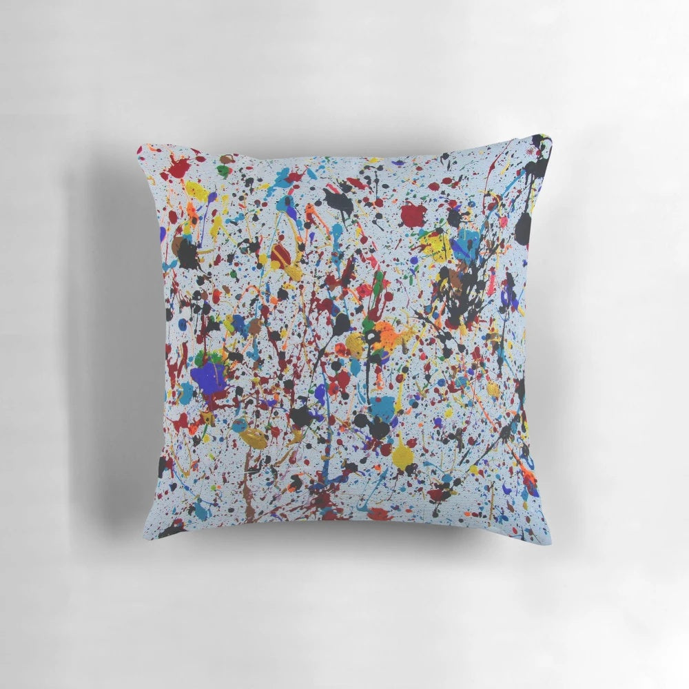 Colorful abstract splatter paint design on a decorative throw pillow
