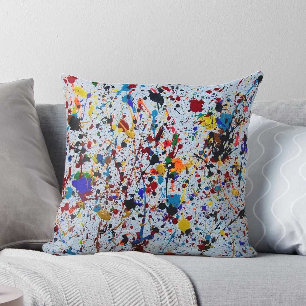 Colorful abstract splatter paint design on a decorative throw pillow