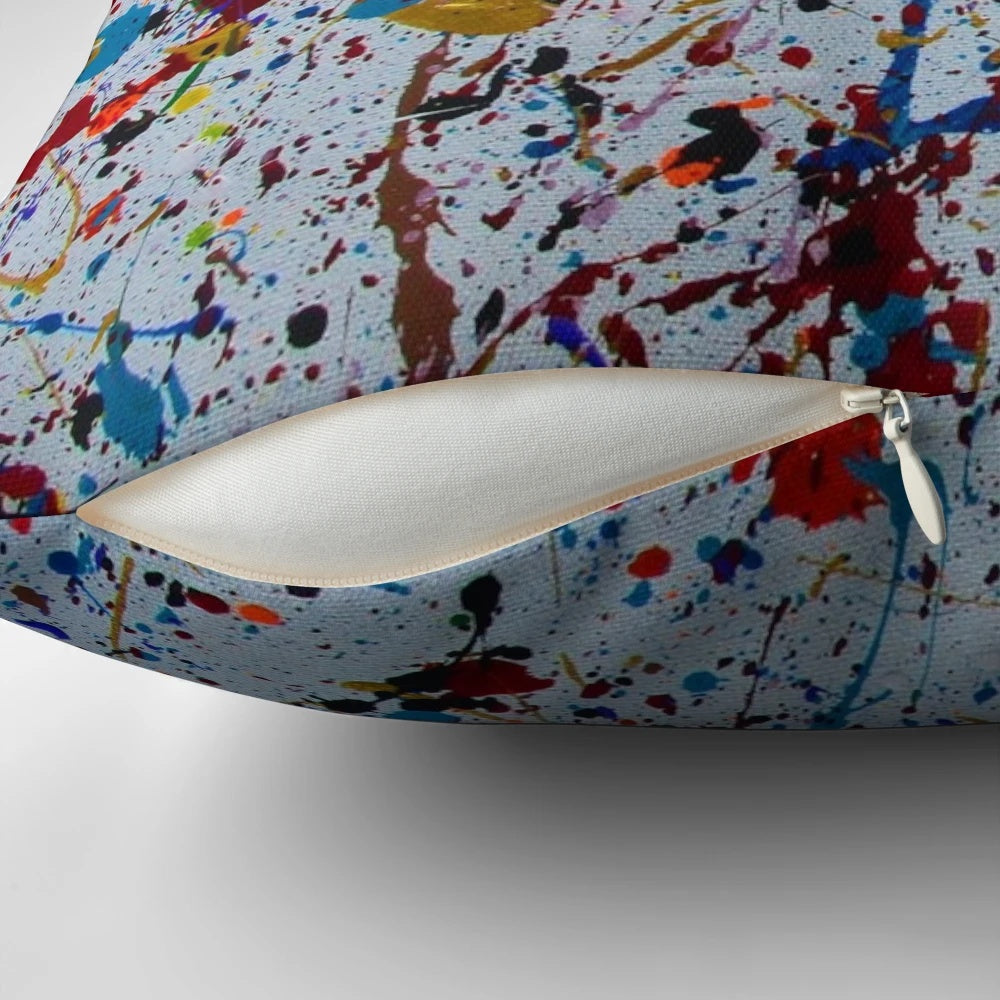 Colorful abstract splatter paint design on a decorative throw pillow