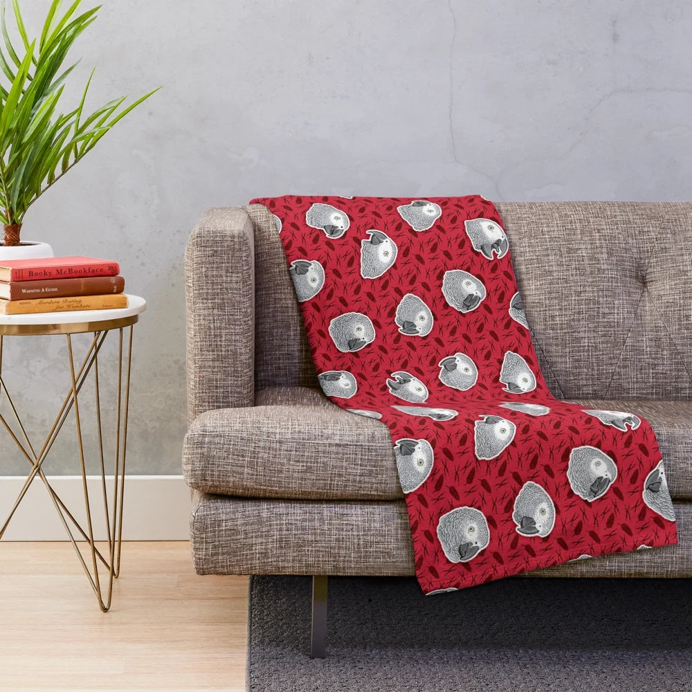 Soft and cozy plush blanket with an eye-catching African grey parrot pattern in red