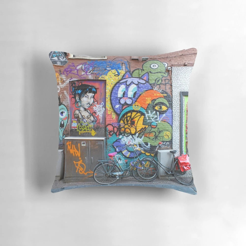 Colorful pillow featuring vibrant Amsterdam street art with graffiti, bicycles, and artistic characters