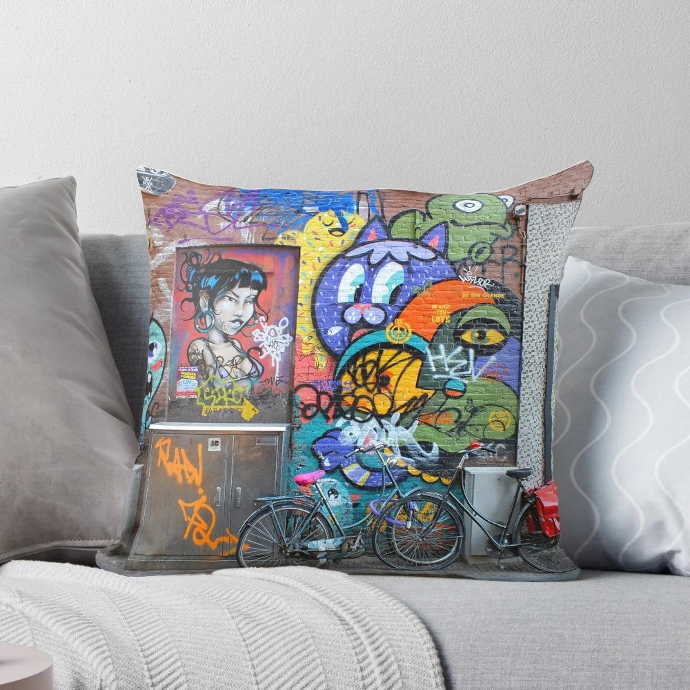 Colorful pillow featuring vibrant Amsterdam street art with graffiti, bicycles, and artistic characters