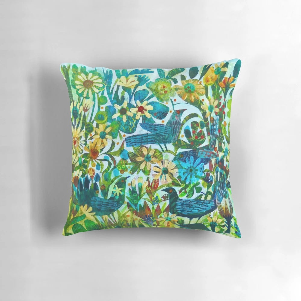 Colorful and unique Este MacLeod designed pillow with birds and flowers in a garden setting.