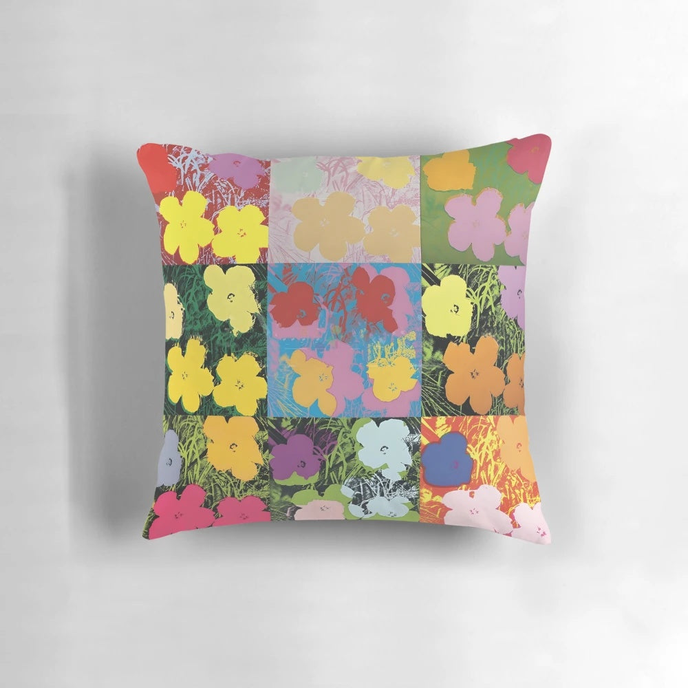 Colorful throw pillow featuring an Andy Warhol-style print of pink, yellow, and orange flowers