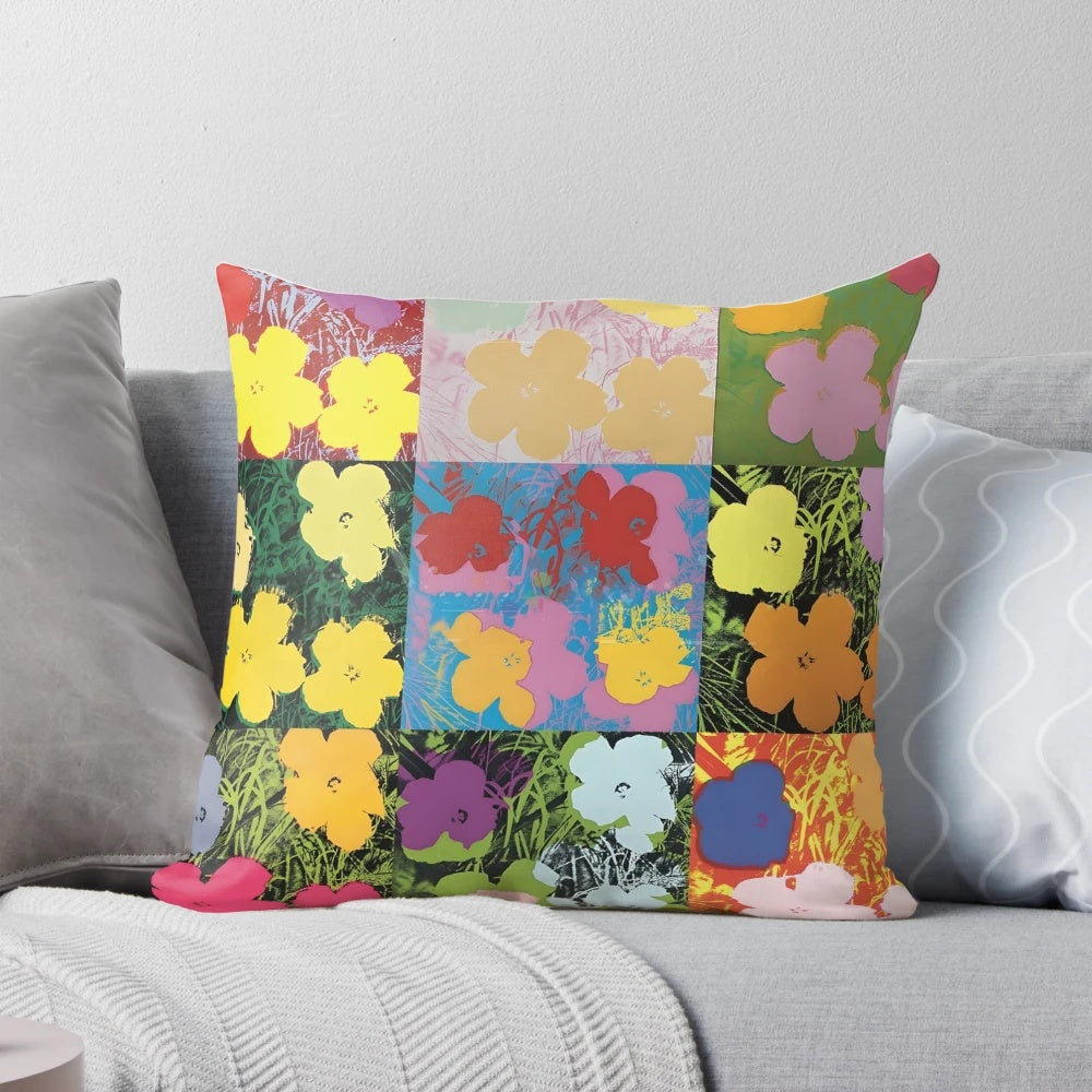 Colorful throw pillow featuring an Andy Warhol-style print of pink, yellow, and orange flowers