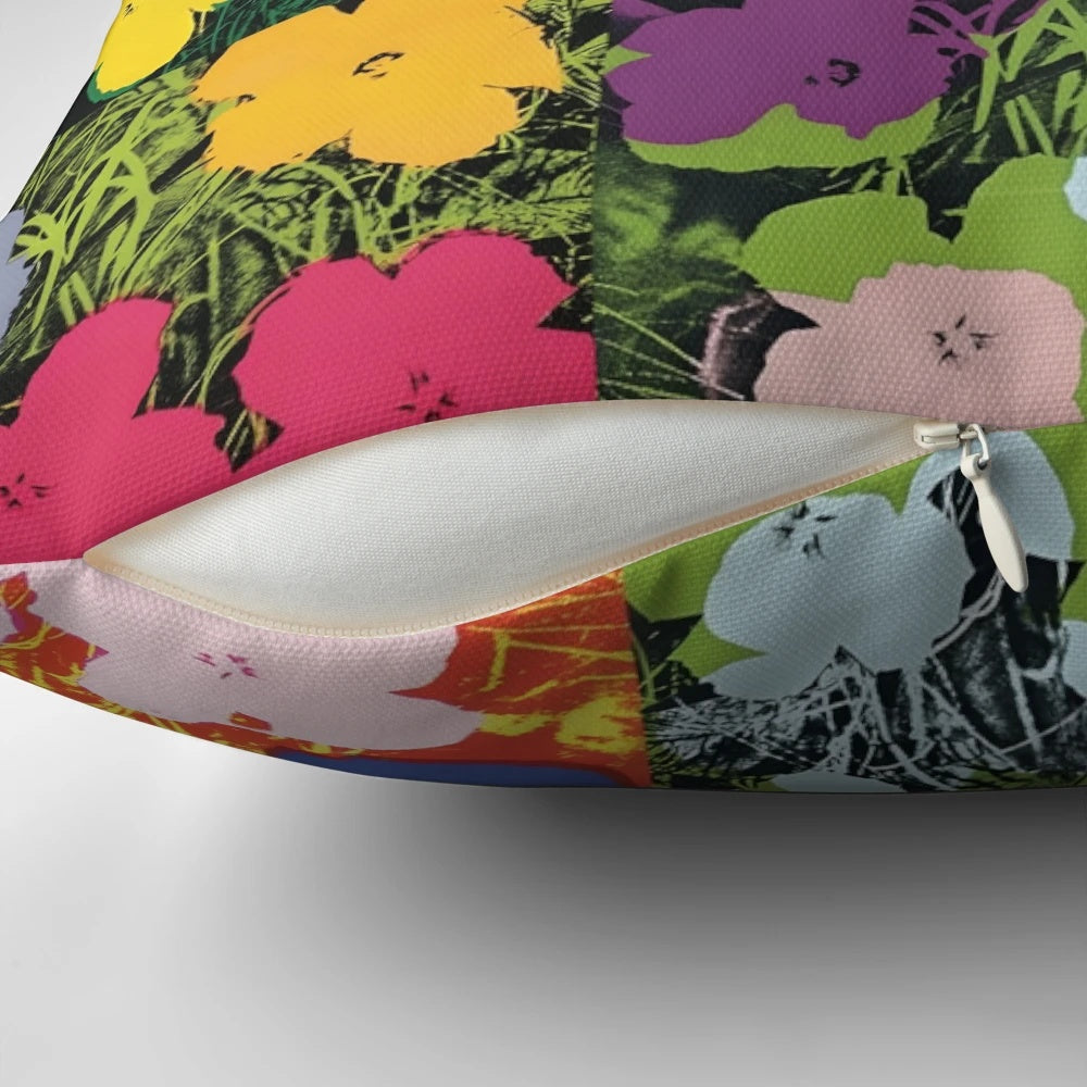 Colorful throw pillow featuring an Andy Warhol-style print of pink, yellow, and orange flowers