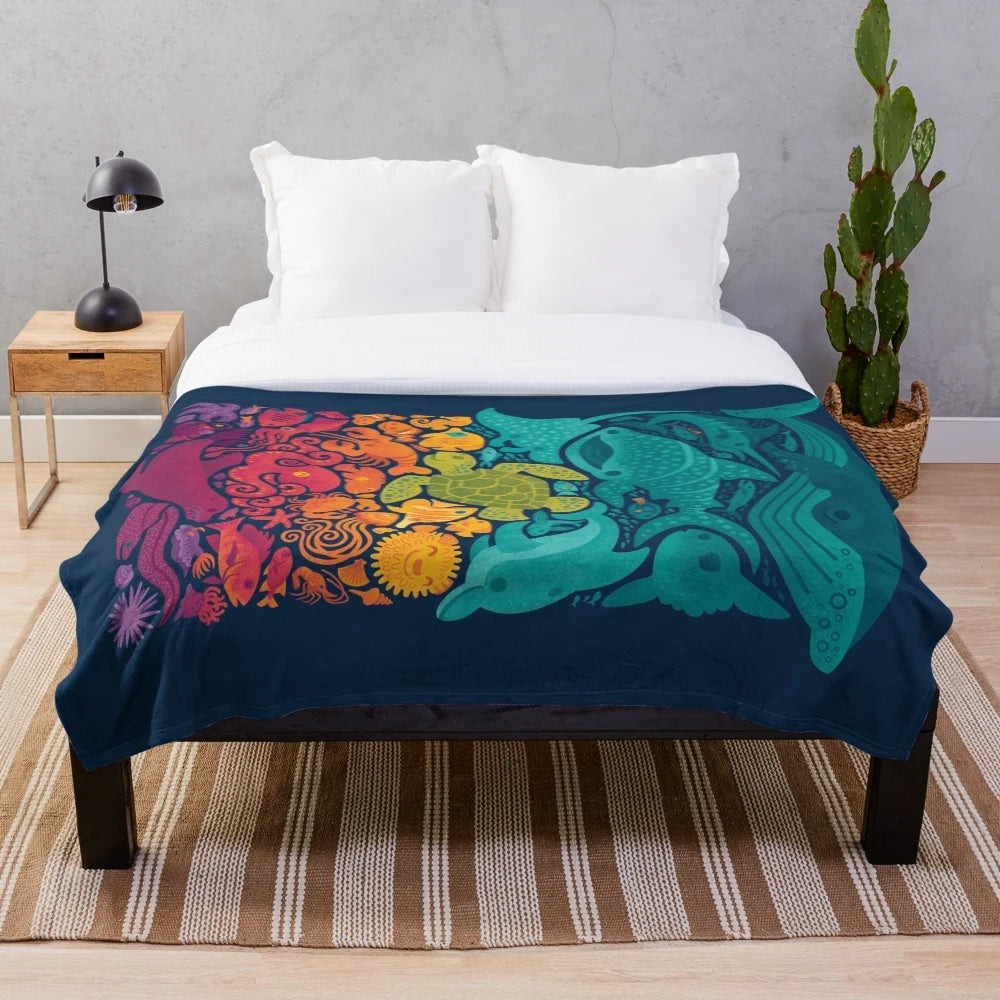 Plush blanket with colorful aquatic spectrum design featuring various ocean creatures