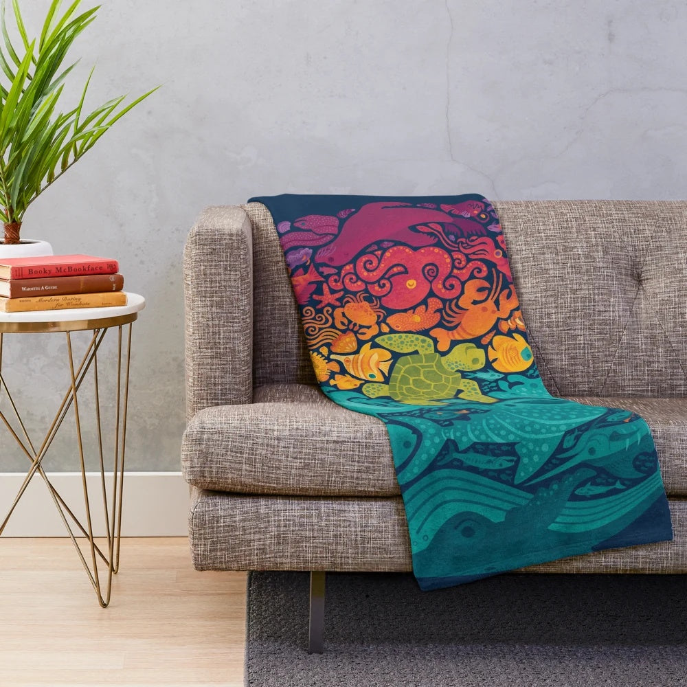 Plush blanket with colorful aquatic spectrum design featuring various ocean creatures