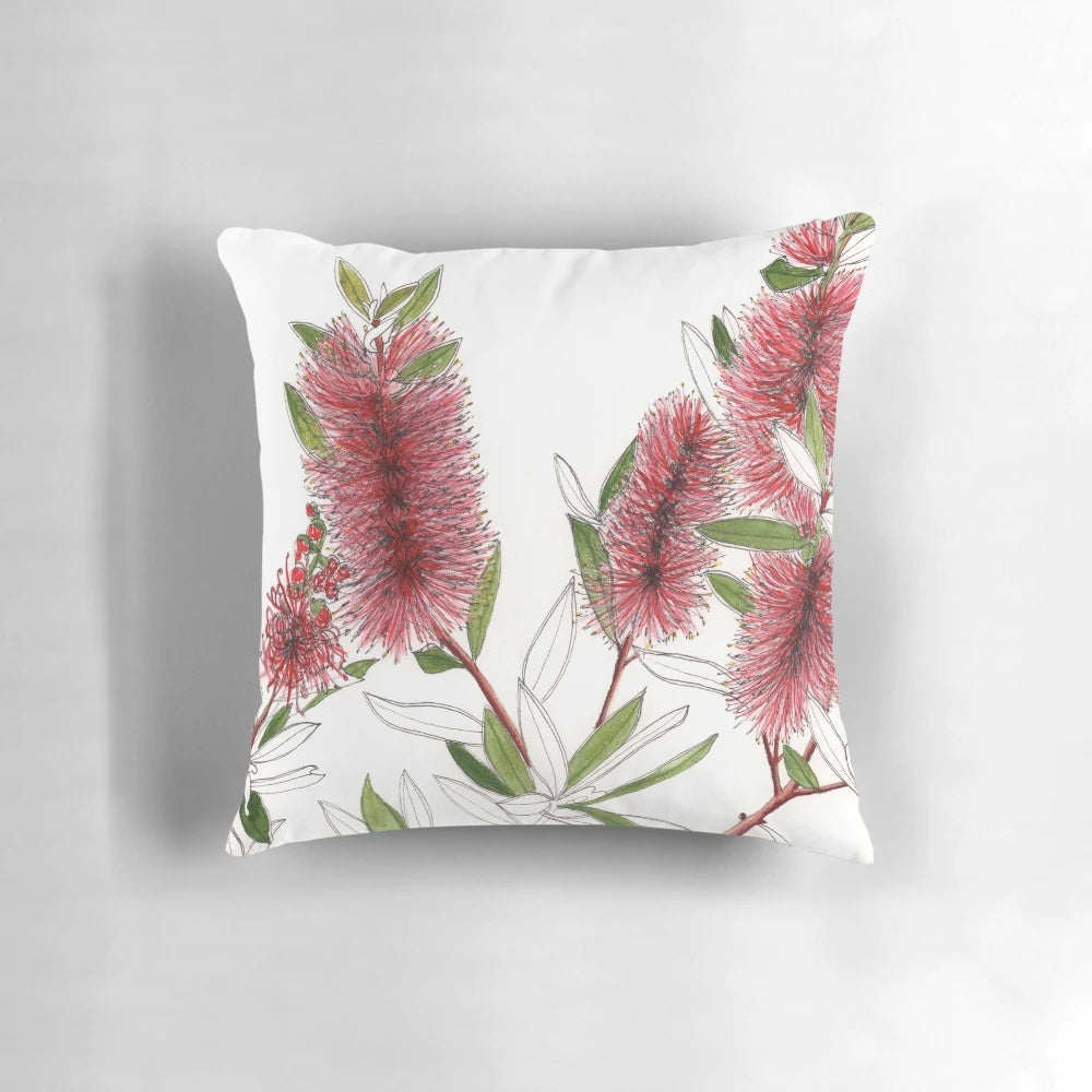 Closeup of a red bottlebrush flower in a watercolor style on a throw pillow