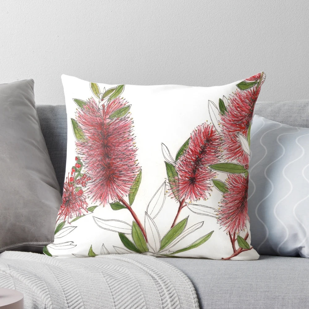 Closeup of a red bottlebrush flower in a watercolor style on a throw pillow
