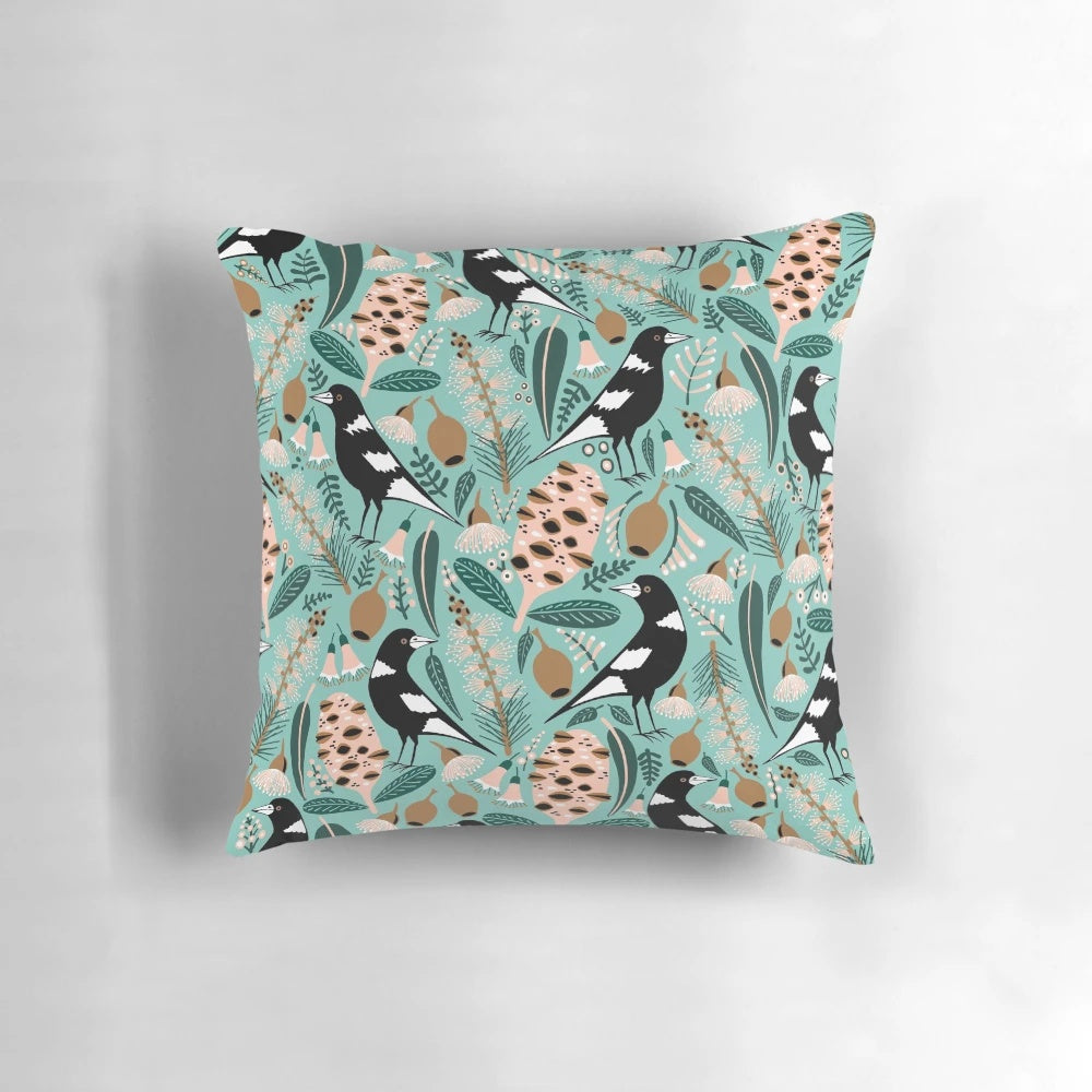 Pillow featuring an illustration of Australian magpies, banksia flowers, and other native flora
