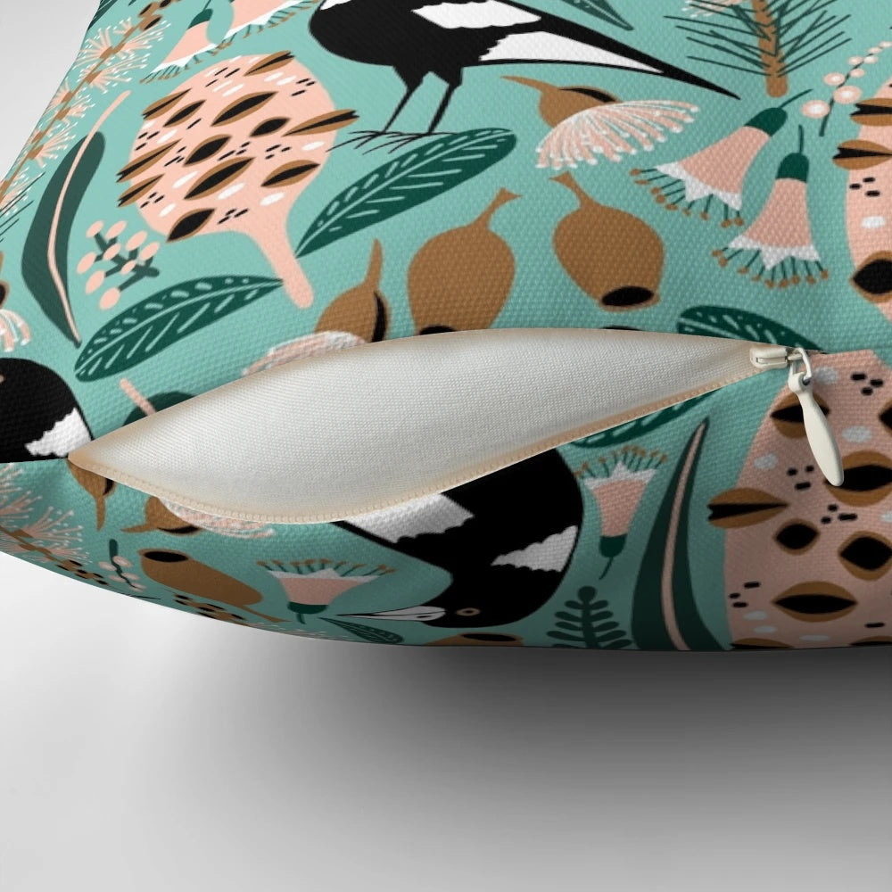 Pillow featuring an illustration of Australian magpies, banksia flowers, and other native flora