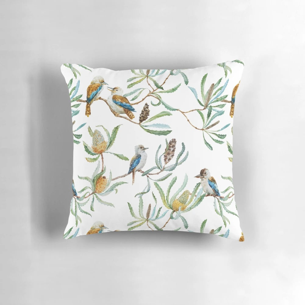 A decorative throw pillow featuring a bright and colorful pattern of Australian kookaburras, yellow waratah flowers, and green leaves on a white background.
