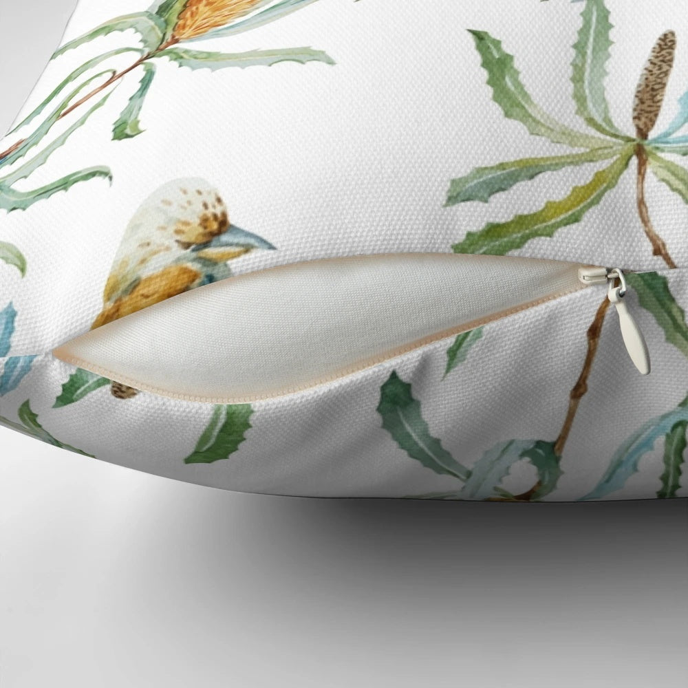 A decorative throw pillow featuring a bright and colorful pattern of Australian kookaburras, yellow waratah flowers, and green leaves on a white background.