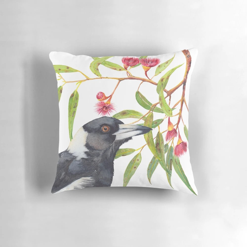 Watercolor painting of an Australian magpie perched on a eucalyptus branch with colorful blossoms.