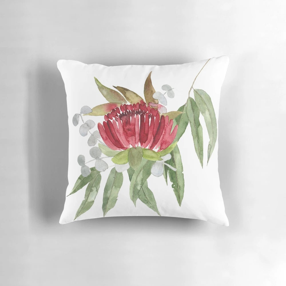 Colorful watercolor painting of Australian native bush flowers and leaves on a decorative pillow