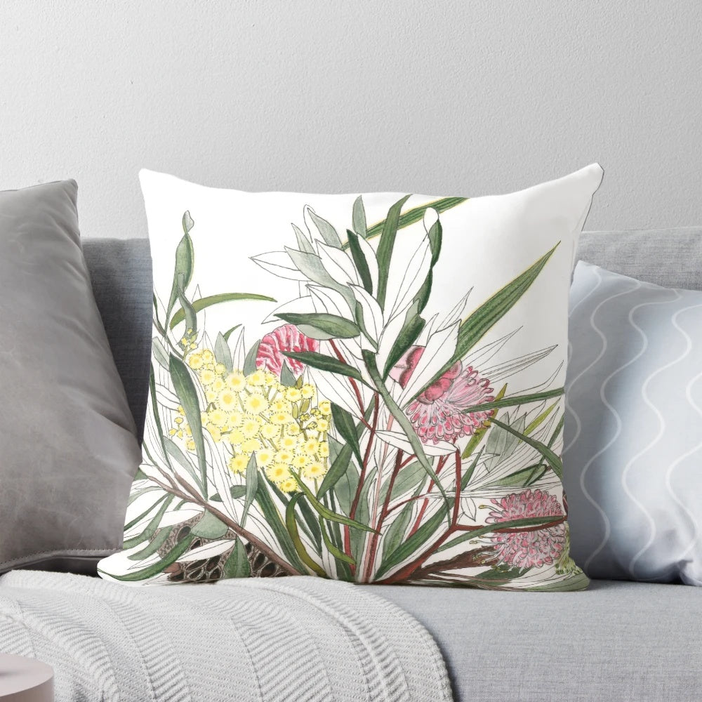 Colorful watercolor-inspired bouquet of Australian native flowers like banksia, grevillea, and wattle on a throw pillow.
