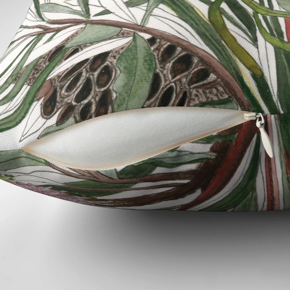 Colorful watercolor-inspired bouquet of Australian native flowers like banksia, grevillea, and wattle on a throw pillow.