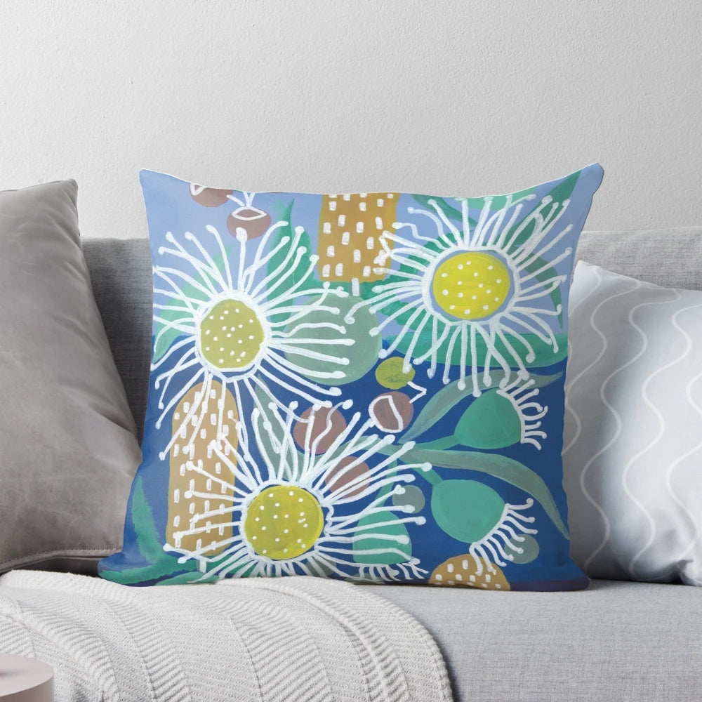 Decorative pillow showcasing a colorful pattern of Australian native flowers, including flowering gum, bottlebrush, and gumnuts.