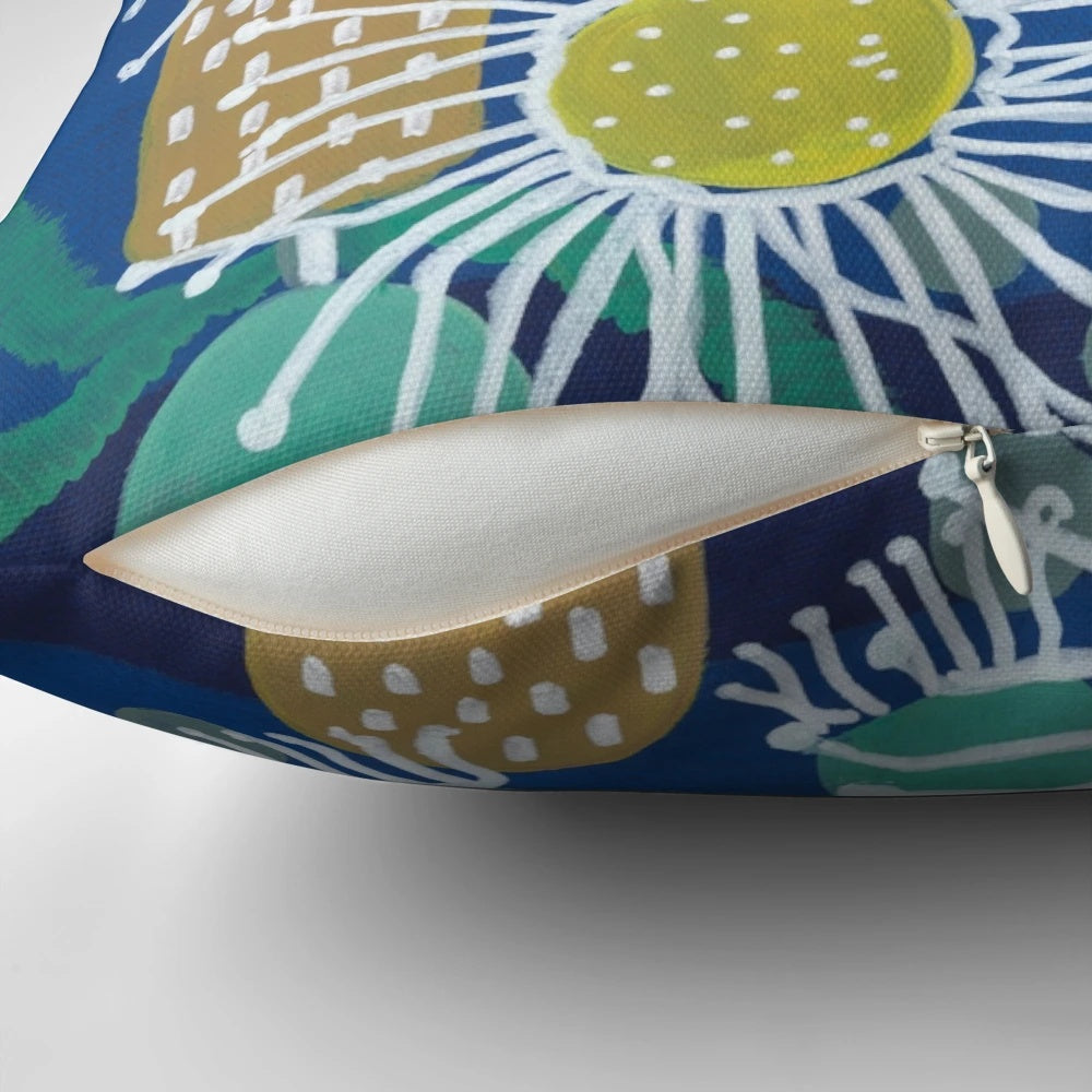 Decorative pillow showcasing a colorful pattern of Australian native flowers, including flowering gum, bottlebrush, and gumnuts.