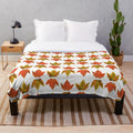 Autumn leaves plush blanket featuring a vibrant orange and red fall foliage design