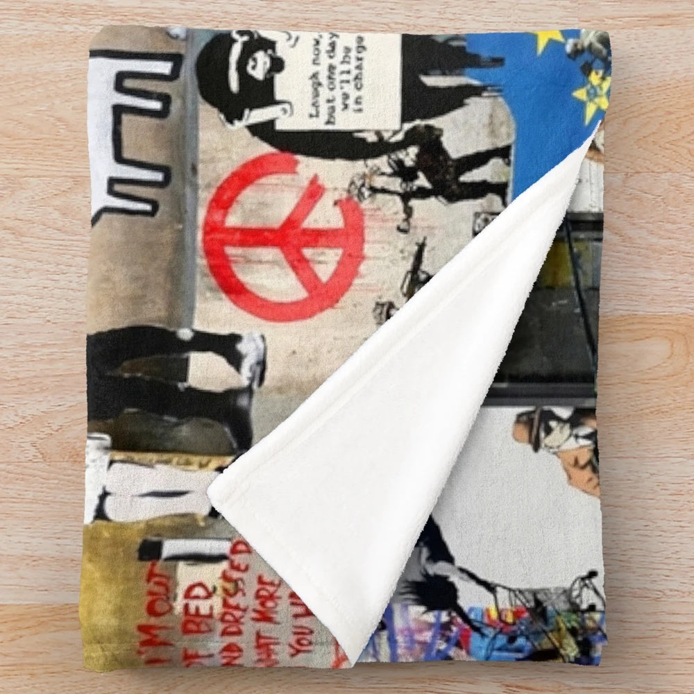 Colorful Banksy-inspired plush blanket with collage of graffiti art, animals, and political imagery