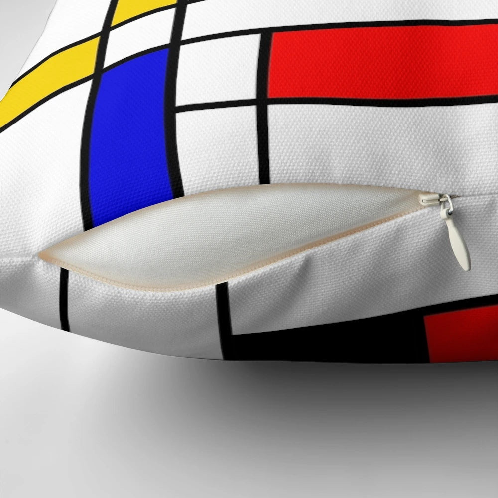 Colorful square and rectangle patterned pillow with blue, red, yellow, black, and white geometric design inspired by Bauhaus and Mondrian styles.