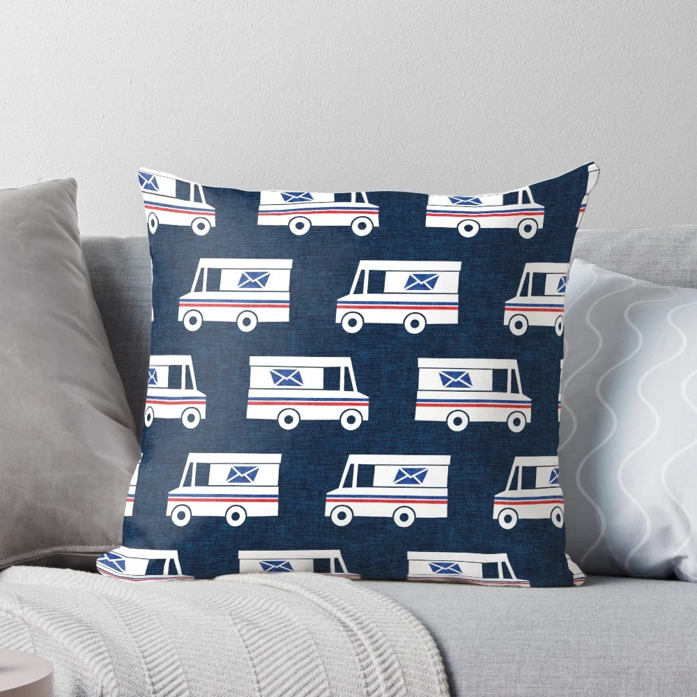 Closeup of a blue pillow with a mail truck and little arrow design printed on it