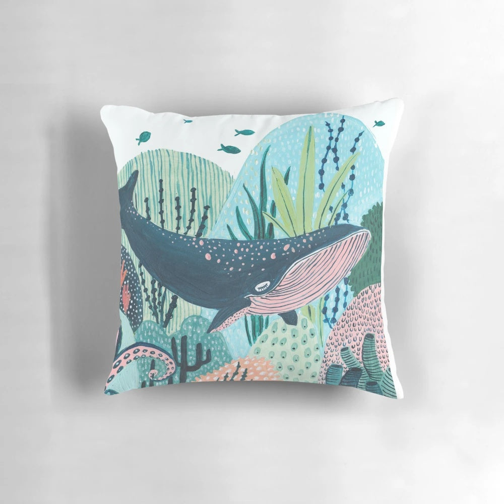 Decorative blue whale pillow with coral, tentacles, and ocean creatures for a whimsical nursery