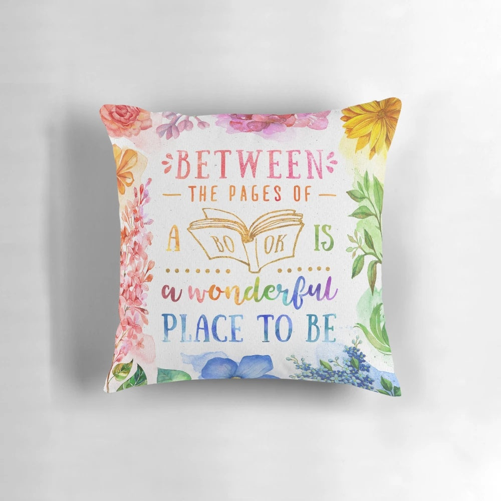 A vibrant, watercolor-inspired throw pillow featuring colorful flowers, leaves, and a bookish design for book lovers.