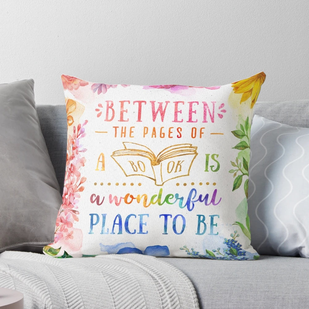 A vibrant, watercolor-inspired throw pillow featuring colorful flowers, leaves, and a bookish design for book lovers.
