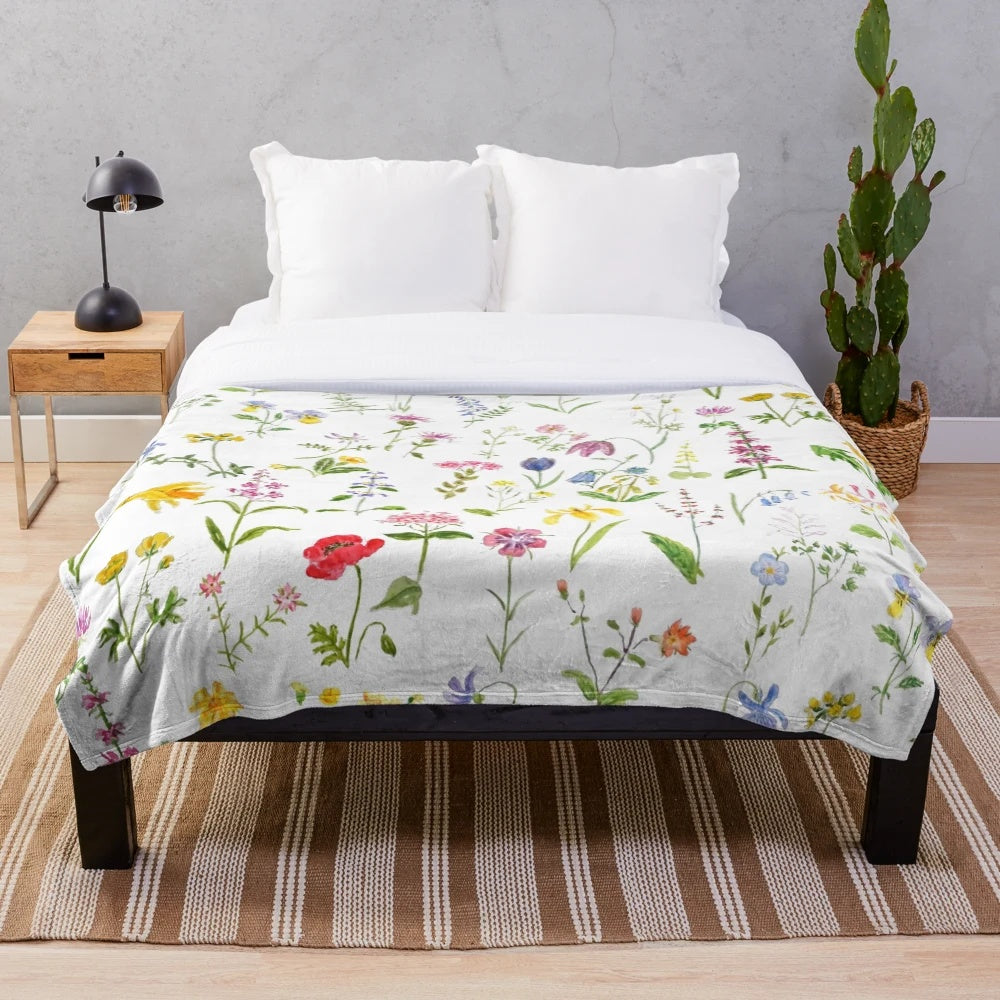 Colorful watercolor painting of wildflowers on a plush blanket