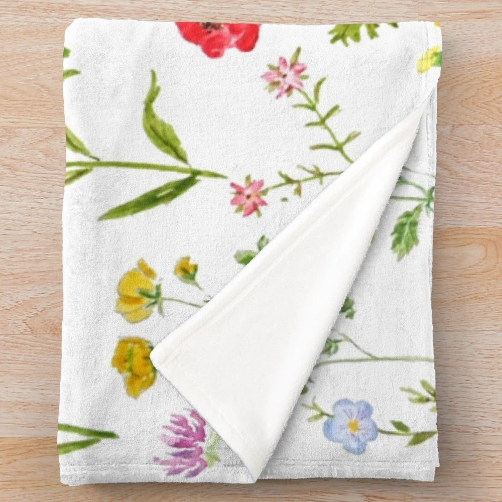 Colorful watercolor painting of wildflowers on a plush blanket