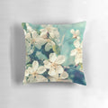 A soft, decorative pillow featuring a close-up image of delicate pink cherry blossoms on a tree branch.